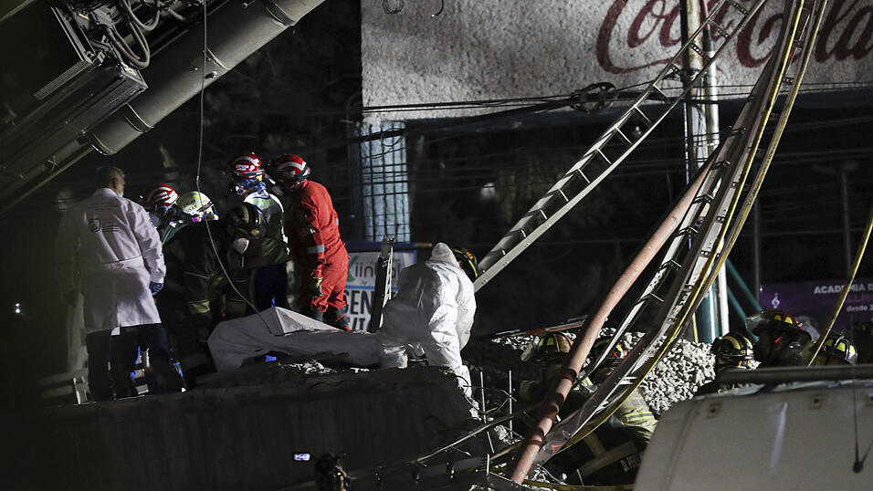 Rettungskräfte tragen die Leiche eines Opfers, nachdem ein Brückenabschnitt der Linie 12 der U-Bahn in Mexiko-Stadt zusammengebrochen ist. Rettungskräfte tragen die Leiche eines Opfers, nachdem ein Brückenabschnitt der Linie 12 der U-Bahn in Mexiko-Stadt zusammengebrochen ist.