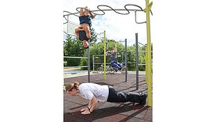 Klaus (oben) trainiert mit Marek (vorne) und Dominik (hinten) in einem Calisthenics-Stangenpark im Straubinger Norden.