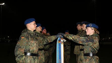 Die Rekruten legen ihre Hand zum Eid auf die Bundesdienstflagge.