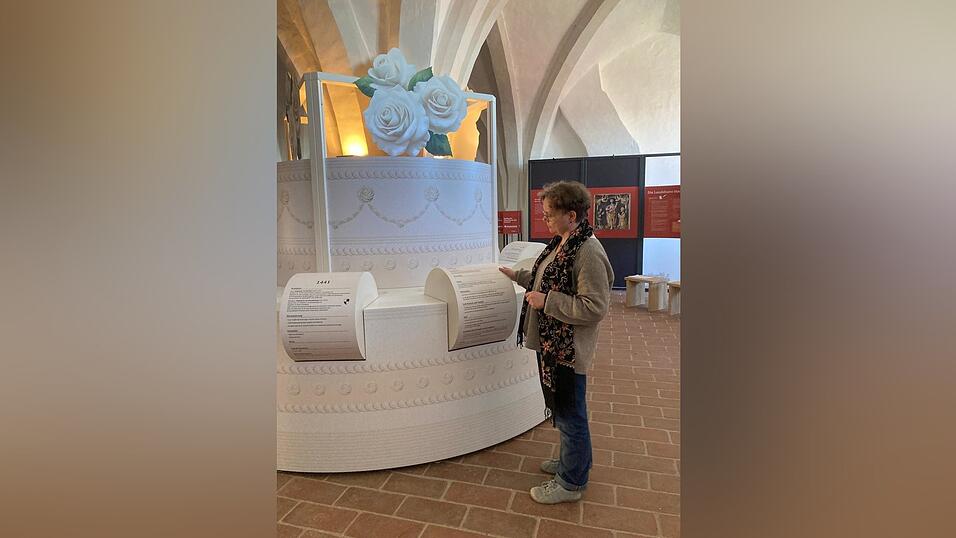 Kuratorin Dr. Tanja Kohwagner-Nikolai vor einer &bdquo;Hochzeitstorte&ldquo; mit Informationen &uuml;ber die gro&szlig;en F&uuml;rstenhochzeiten im 15. Jahrhundert.