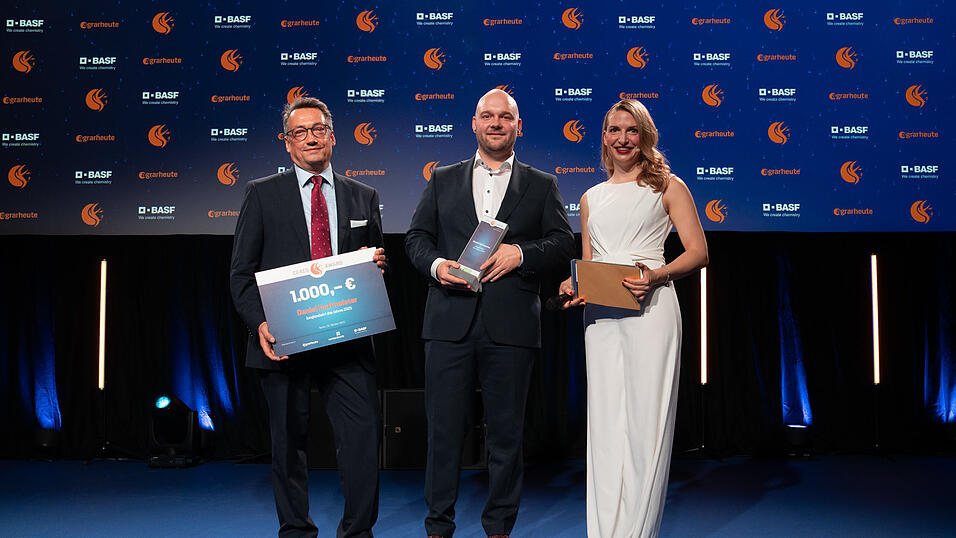 Der Junglandwirt des Jahres 2025 Daniel Dorfmeister (Mitte) mit Markus Röser (Kategoriepartner BASF) und Moderatorin Janine Mehner.