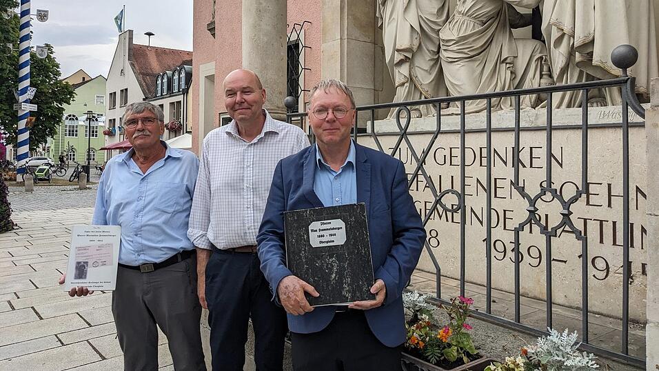 Dekan Stadtpfarrer Josef Geismar (M) und die Historiker Eduard Hasler (l.) und Albert Eichmeier halten die Erinnung an Maximilian Frommberger hoch. Foto: Roman Hiendlmaier