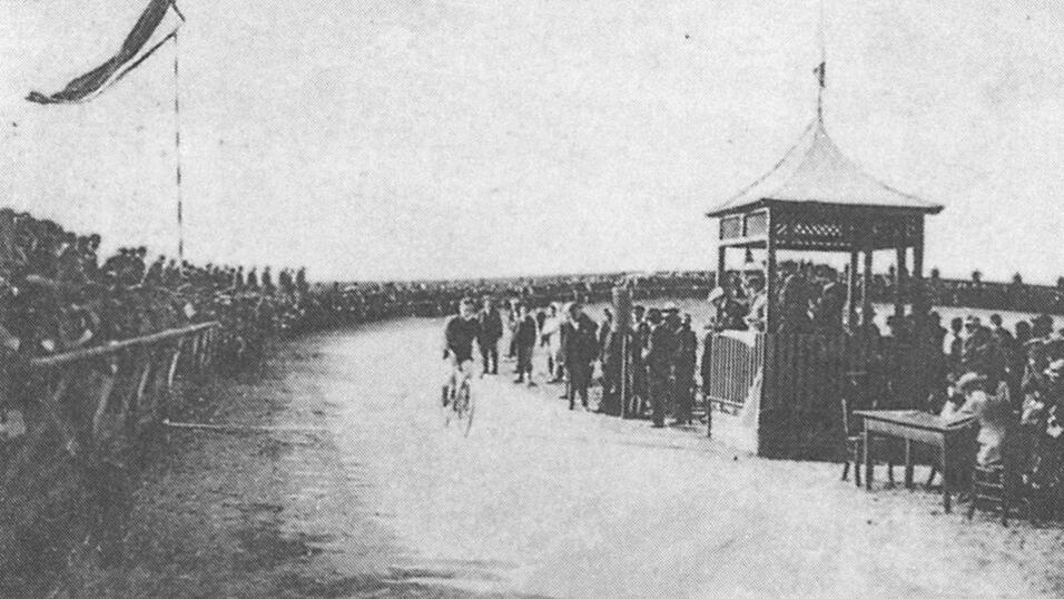 Dicht gedr&auml;ngt verfolgt eine gro&szlig;e Zuschauerschaft ein Radrennen auf der Sch&ouml;nbrunner Radrennbahn. F&uuml;r ihre Zeit war sie gut ausgestattet mit eigenem Belag, einem Eingangstor, Starthaus und Trib&uuml;nen.