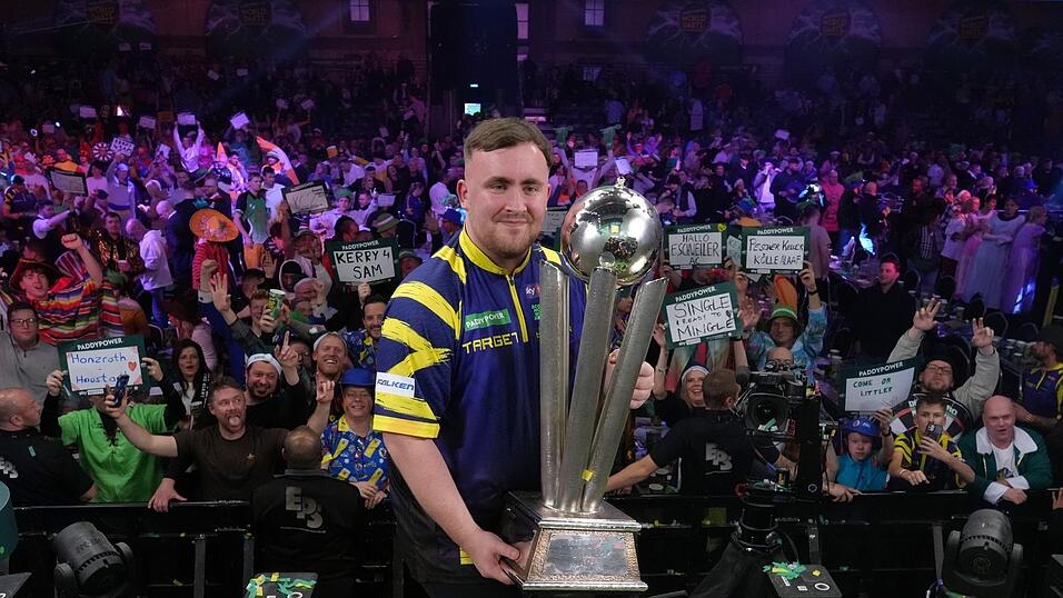 Littler präsentiert zum zweiten Mal die WM-Trophäe. Littler präsentiert zum zweiten Mal die WM-Trophäe.