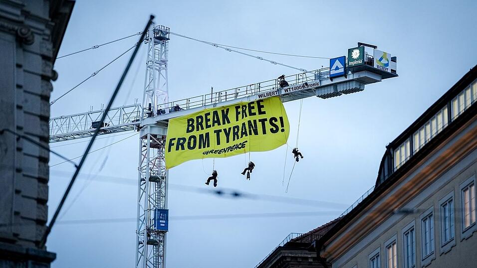 Aktivisten seilen sich von einem Kran in der N&auml;he der M&uuml;nchner Sicherheitskonferenz ab.