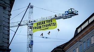 Aktivisten seilen sich von einem Kran in der N&auml;he der M&uuml;nchner Sicherheitskonferenz ab.
