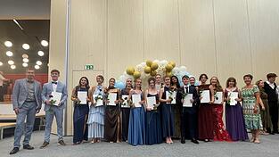Die 15 Pr&uuml;fungsbesten des Gymnasiums Seligenthal mit Oberstufenkoordinator Sirko M&uuml;ller (links) und Schulleiterin Ursula Weger (rechts). F&uuml;r Weger war es die letzte Abschlussfeier vor ihrem Ruhestand.