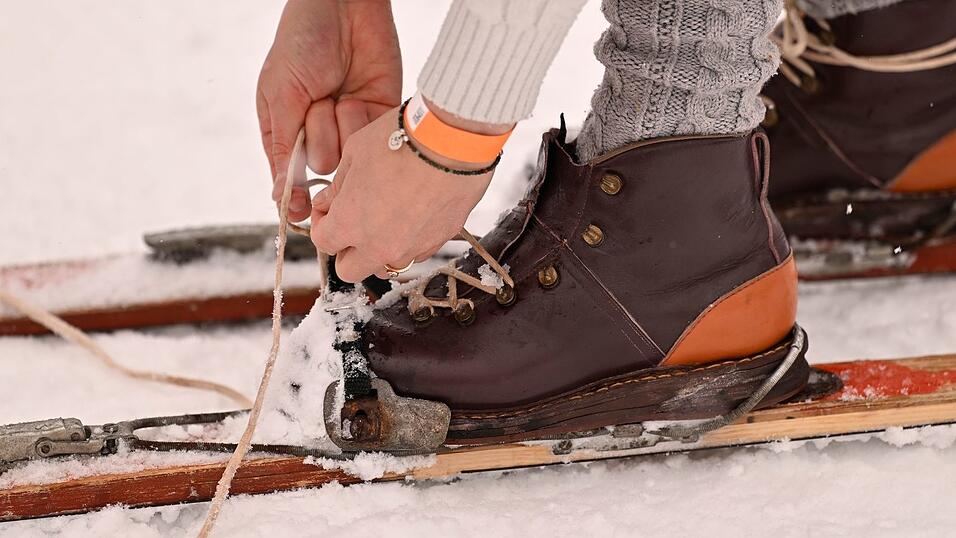 Historische Holzski ohne Plastikbelag, Lederschuhe und Seilzugbindung sind Pflicht.