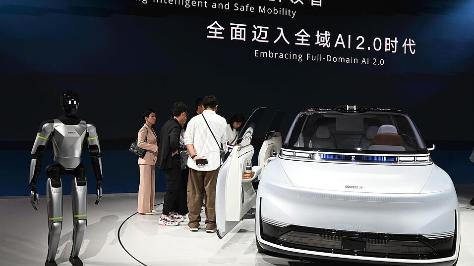 Hier pr&auml;sentiert Geely ein Auto samt humanoidem Roboter auf einer Automesse in Peking. Nun wagt die Firma den Sprung nach Spanien, um dort Autos zu bauen.