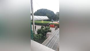 Beamte eines Spezialeinsatzkommandos bringen den 49-J&auml;hrigen in Fu&szlig;fesseln zu einem Polizeihubschrauber.