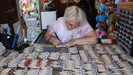 Marion Knipf beschriftet Glupperl am Gäubodenvolksfest. Dafür braucht es eine ruhige Hand und gutes Augenmaß.