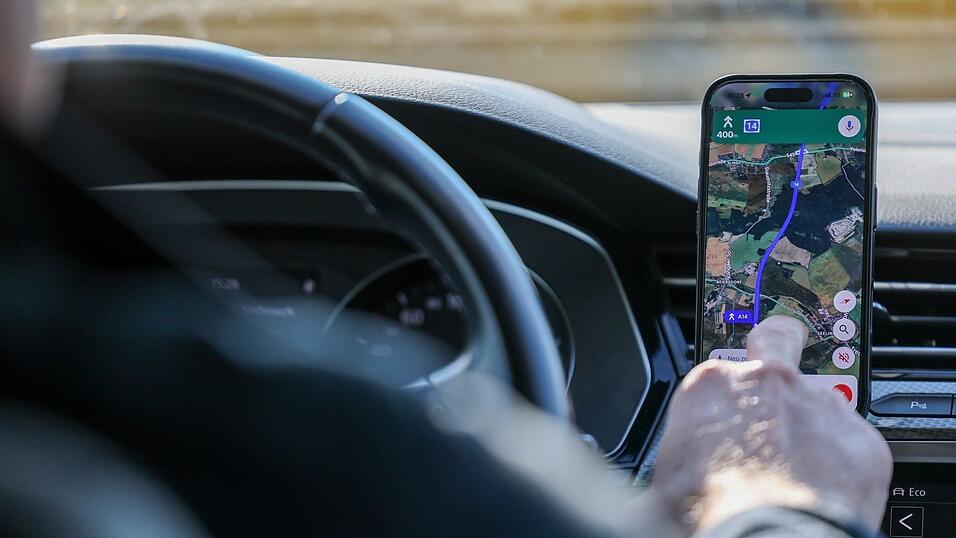 So ist es derzeit erlaubt: Das Handy steckt in der Halterung und wird nur kurz vom Fahrer beachtet. (Symbolbild)