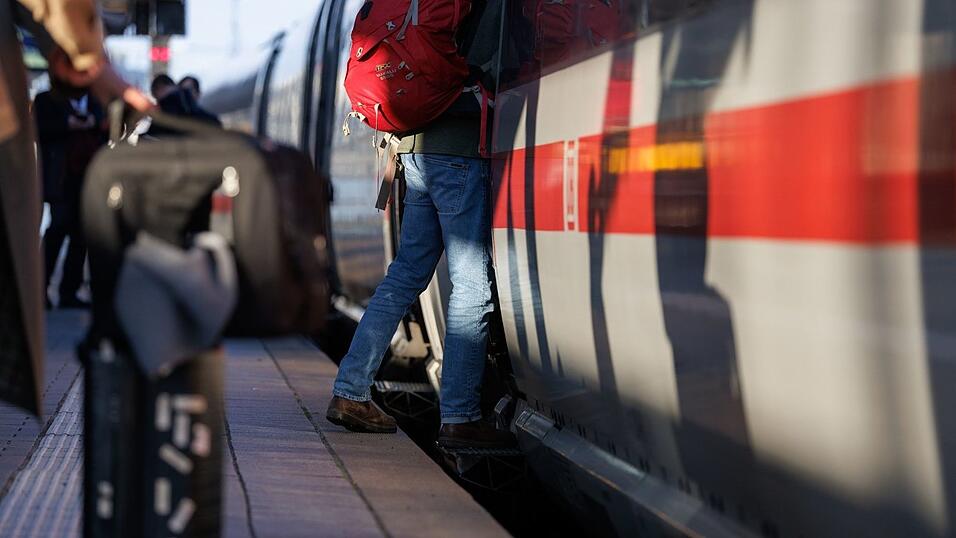 Reisende stehen mit Gepäck am Bahnsteig am Nürnberger Hauptbahnhof an einem ICE.