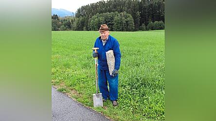 Feldgeschworener Gerhard Kienberger mit originalem Grenzstein und Arbeitsgerät Spaten.
