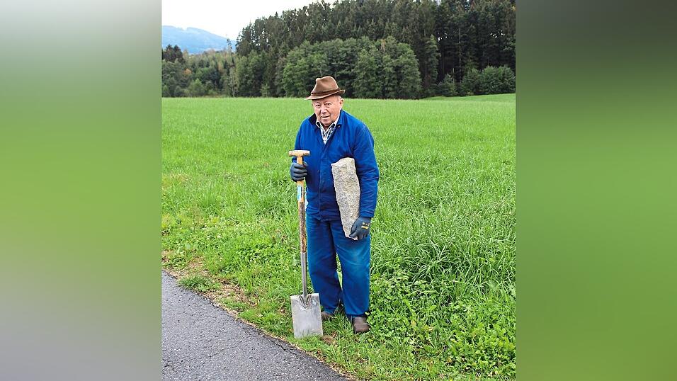 Feldgeschworener Gerhard Kienberger mit originalem Grenzstein und Arbeitsgerät Spaten.