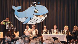 Die f&uuml;nf B&uuml;rgermeisterkandidaten f&uuml;r Mainburg sa&szlig;en bei den &bdquo;Wahlges&auml;ngen - Gstanzl f&uuml;r Mainburg&ldquo; auf der B&uuml;hne: (von rechts) Annette Setzensack, Messalina Sedlmeier, Helmut Fichtner, Karoline Fritz-Ertlmaier und Thomas Kastner. Ritsch Ermeier (links) sang Gstanzl und Martin Rank moderierte den Abend.