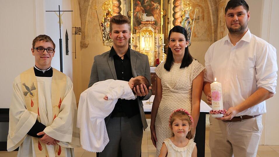 Die Eltern und die vierj&auml;hrige Schwester Pia (r.) zusammen mit dem Taufpaten und dem kleinen T&auml;ufling Thea Feline sowie Kaplan Michael Steinhilber (l.)