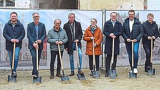 Die Bauherren Rainer Priglmeier (Sechster von rechts) und Andreas Bachmeier (F&uuml;nfter von rechts) brachten zum offiziellen Start des anspruchsvollen Bauprojekts mit den beteiligten Handwerksbetrieben und Planern individualisierte Spaten mit.