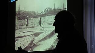 Der Referent vor einem Bild, das die zugefrorene Isar im Jahr 1929 zeigt.