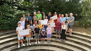Freude bei der Spenden&uuml;bergabe im Gymnasium Seligenthal: Organisatoren, Vertreter der beg&uuml;nstigten Einrichtungen, Schulleiterin Ursula Weger (hintere Reihe, Siebte von rechts), Alfons Bachhuber (hintere Reihe, Achter von rechts) sowie Sch&uuml;ler pr&auml;sentierten die vier Spendenschecks &uuml;ber jeweils 4.500 Euro. Insgesamt kamen bei der Benefizaktion &bdquo;Kinder laufen f&uuml;r Kinder&ldquo; 18.000 Euro zusammen.