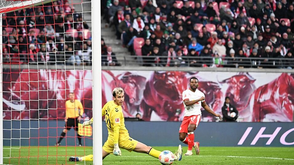 Bremens Torwart Mio Backhaus (l, Werder Bremen) und Ridle Baku (RB Leipzig) schauen dem Ball hinterher. Backhaus verhinderte mit seinen Paraden einen frühen Rückstand der Gäste in Leipzig.