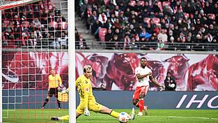 Bremens Torwart Mio Backhaus (l, Werder Bremen) und Ridle Baku (RB Leipzig) schauen dem Ball hinterher. Backhaus verhinderte mit seinen Paraden einen frühen Rückstand der Gäste in Leipzig.