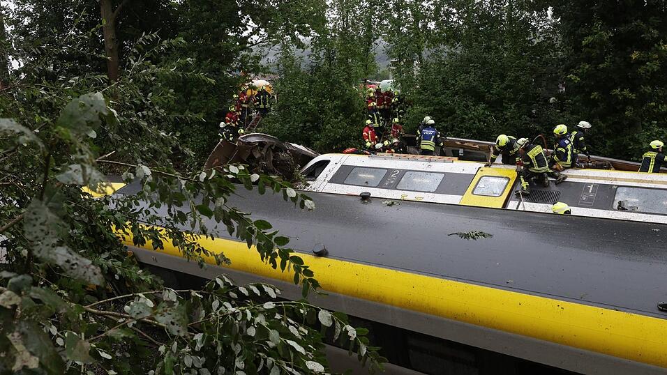 Einsatzkräfte versuchen, die Fahrgäste aus dem entgleisten Zug zu retten. Einsatzkräfte versuchen, die Fahrgäste aus dem entgleisten Zug zu retten.