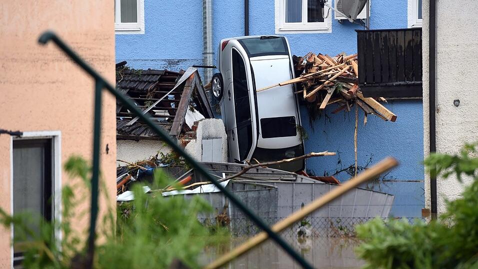 Ein Auto, das von den Wassermassen hochkant zwischen Treibgut an eine Hausfassade gedr&uuml;ckt wurde, ist am 1.06.2016 in Simbach am Inn zu sehen.