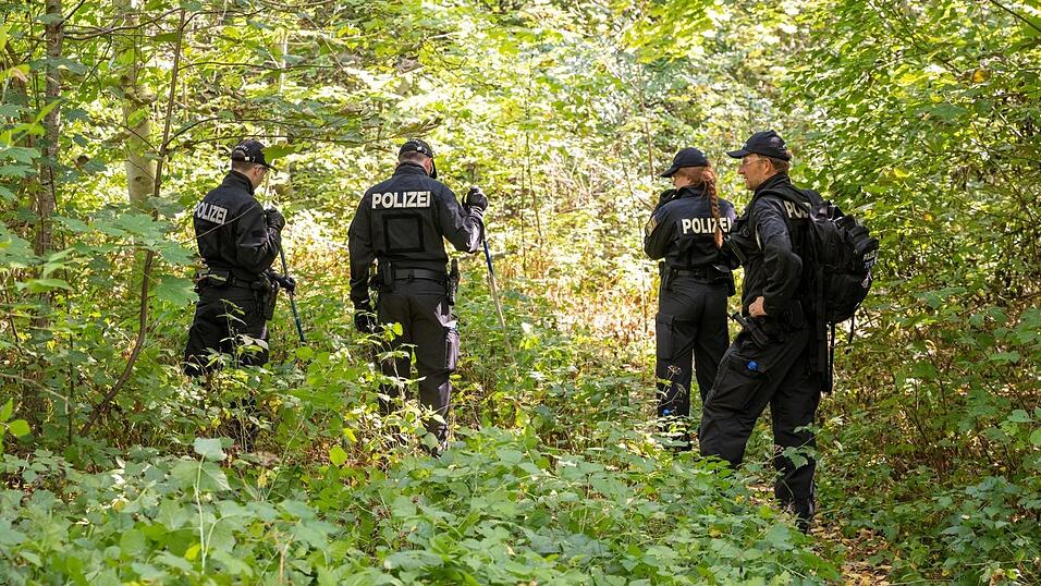 Polizisten durchsuchen ein Waldstück nach Spuren und Gegenständen, in dessen Nähe am 17. August eine weibliche Leiche in einem Auto entdeckt wurde.