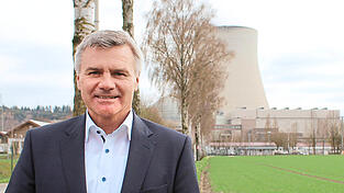 Landrat Peter Dreier vor dem Kühlturm des Kernkraftwerks Isar 2.