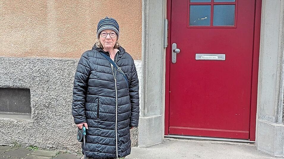 Baugenossin Gerda Dinauer vor ihrer Haustür mit dem ehemaligen Türschlitz.