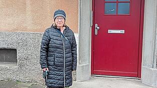 Baugenossin Gerda Dinauer vor ihrer Haustür mit dem ehemaligen Türschlitz.