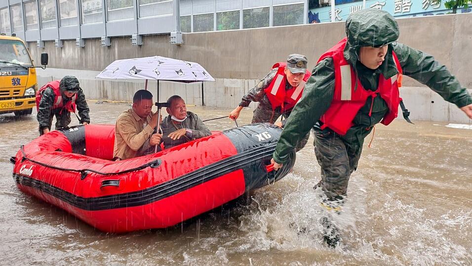Retter helfen mit Schlauchbooten nach den starken Regenf&auml;llen in Qinzhou.