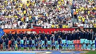 Die Fu&szlig;ball-Nationalmannschaft steht beim Abspielen der Nationalhymne am Mittelkreis.