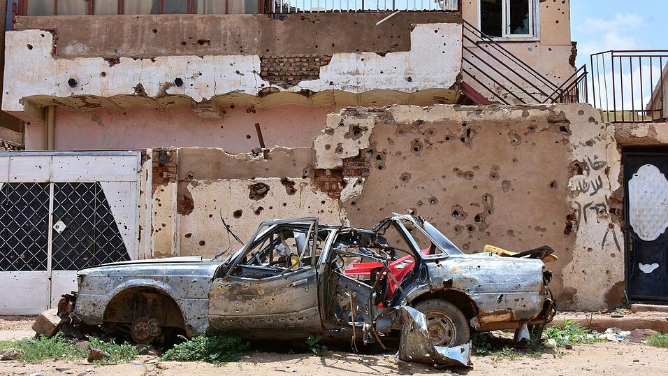 Ein zerst&ouml;rtes Auto steht im sudanesischen Omdurman vor einem Haus voller Einsch&uuml;sse. (Archivbild)