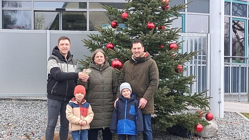 Die beiden Nikol&auml;use Florian Wieser (links) und Sebastian Reiser mit ihren beiden Kindern Maximilian und Ludwig zusammen mit der Elisabeth Ruf von der Kinder-Palliativ-Hilfe Niederbayern bei der Spenden&uuml;bergabe.
