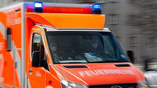 Ein Rettungswagen der Feuerwehr fährt auf einer Straße. Ein Rettungswagen der Feuerwehr fährt auf einer Straße.