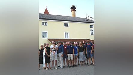 Jungstorch Finn blickt von oben auf seine Unterstützerschar im Brauereihof um die Familie Hofbauer, die Feuerwehren, LBV und OGV, Horstbetreuerin, Nestring-Bauer und auf seinen Namensvetter auf Vaters Arm.