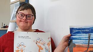 Anna mit zwei Seiten des Buches. Noch liegt es nur in einzelnen Ausdrucken, aber nicht in gebundener Form vor. Illustrator Eric Schneider ist aber schon auf der Suche nach einem Verlag.