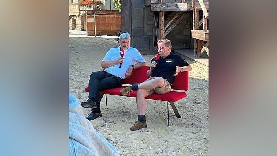 Gem&uuml;tlicher Ratsch zweier Schwarzer auf einer roten Bank mitten auf der Sandbahn. Was es damit auf sich hat?