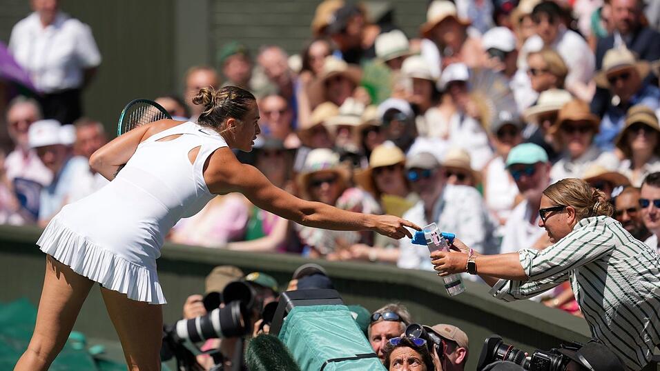 Aryna Sabalenka bringt eine Wasserflasche und ein Kühlpack zur Tribüne, wo es einer Zuschauerin nicht gut geht.