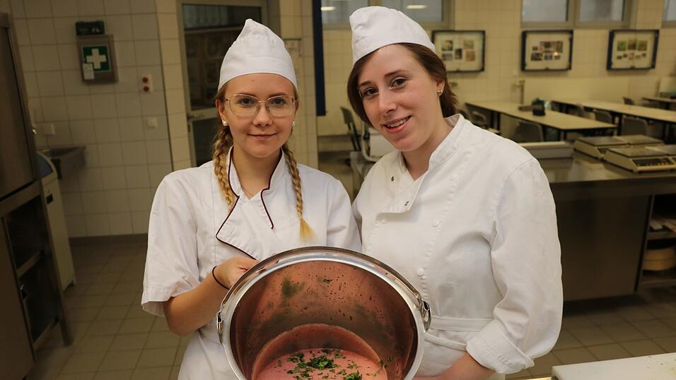 Franziska (links) und Sandra mit der flüssigen Eismischung. In ihr befinden sich alle Zutaten für das Eissorbet. Obendrauf in Grün: die frisch geschnittenen Kräuter.