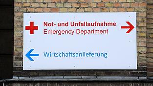 Ein Schild mit der Aufschrift 'Not- und Unfallaufnahme' und 'Wirtschaftsanlieferung' hängt am Krankenhaus.