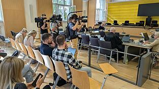 Journalisten und TV-Teams warten auf den Beschuldigten im Regensburger ICE-Prozess. Der Verteidiger J&ouml;rg Meyer und der Dolmetscher des Syrers haben schon im Landgericht Platz genommen.
