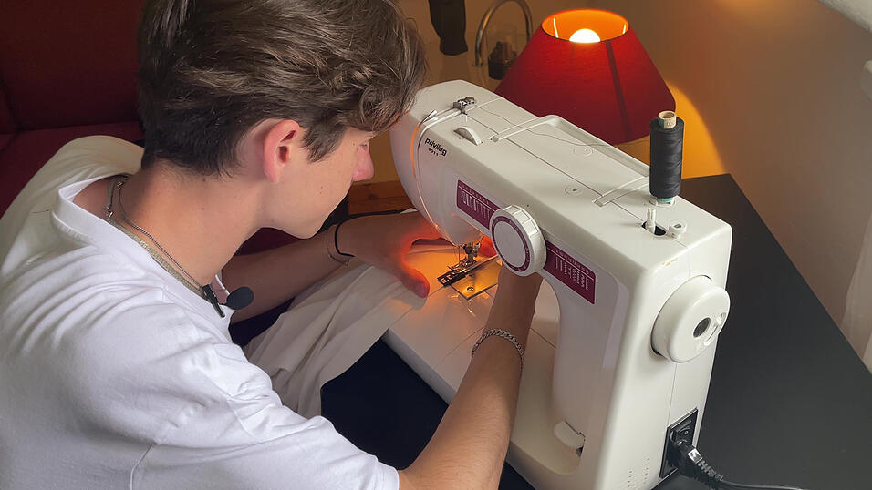 4. Nähen: Im letzten Schritt bringt Julius noch zwei Labels am T-Shirt an. Zum einen einen Einnäher mit dem Logo seiner Marke im Nacken. Zum anderen ein Label mit dem Namen der Kollektion am unteren Rand des Shirts. Beides befestigt er ganz einfach mit der Nähmaschine. Wie das Siebdrucken insgesamt hat sich Julius auch das Nähen mit Tutorials auf YouTube beigebracht.