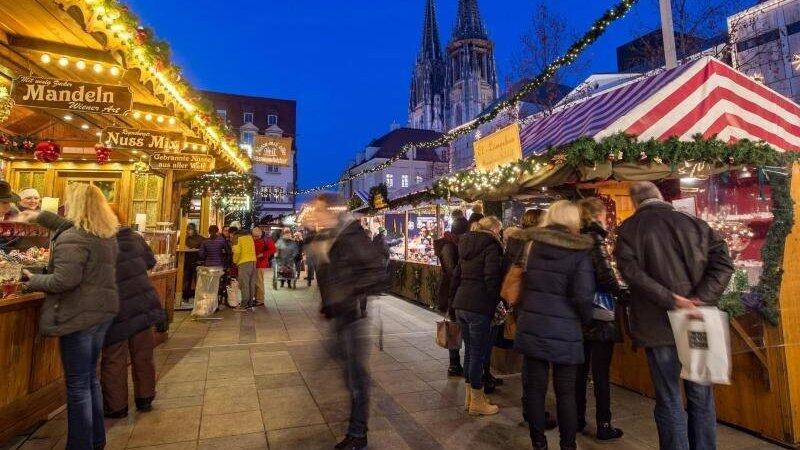 Besucher gehen &uuml;ber den Weihnachtsmarkt auf dem Regensburger Neupfarrplatz (Archiv).