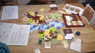 Einer von zwei Prototypen wird mit Spielmaterial aus &bdquo;Die Siedler von Catan&ldquo; gespielt. Bereits hier erkennt man die Aufteilung des Spielplans mit Pilsting im Norden, Landau im S&uuml;den und der Isar als Grenzfluss.