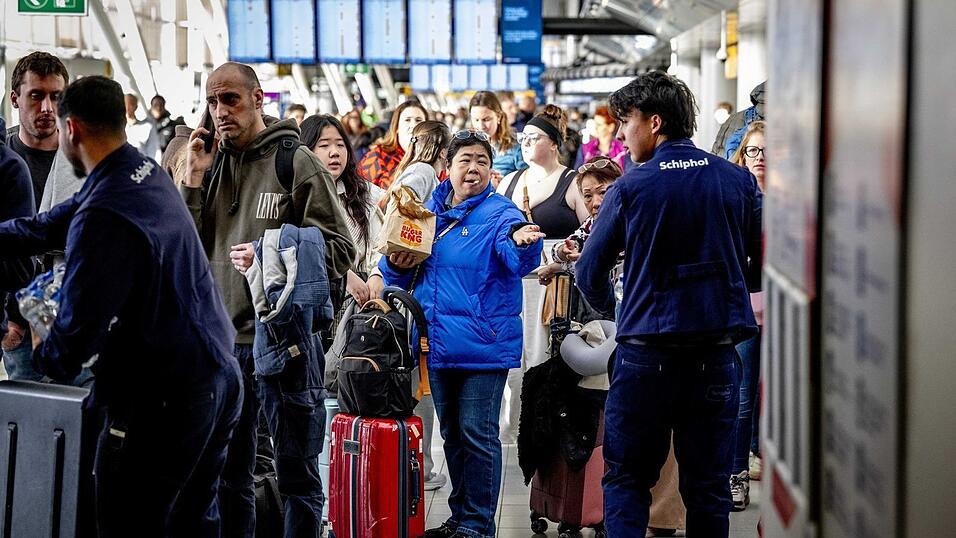Reisende stehen Schlange am Serviceschalter der Fluggesellschaft KLM&nbsp;am Flughafen Schiphol.