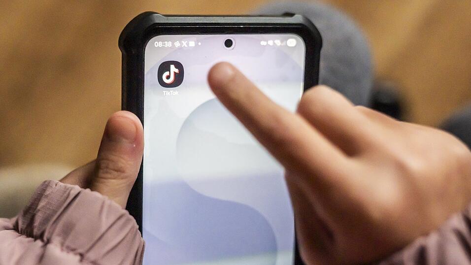 Ein junges M&auml;dchen nutzt die Social-Media-App TikTok auf einem Mobiltelefon (gestellte Szene).
