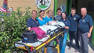 Karin Borchers (Mitte) sowie Sonja Muhr (Dritte von rechts) und Tobias Muhr (links) begleiteten Paula im Herzenswunschmobil nach Regensburg. Ihren Liegendrollstuhl transportierten Sigi Iglhaut (rechts) und Tobias Eichstetter (Zweiter von rechts) dorthin. Das Team des Kinderhauses in Roding (auf dem Bild sind Hanna Hrachovcová, Dritte von links, und Natascha Merker, Zweite von links, zu sehen) hatte das Mädchen auf seinen Kommuniontag vorbereitet.